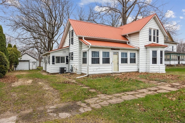 view of front facade featuring cooling unit, a garage, an outdoor structure, and a front yard