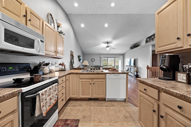 kitchen with light brown cabinets, kitchen peninsula, vaulted ceiling, a textured ceiling, and white appliances