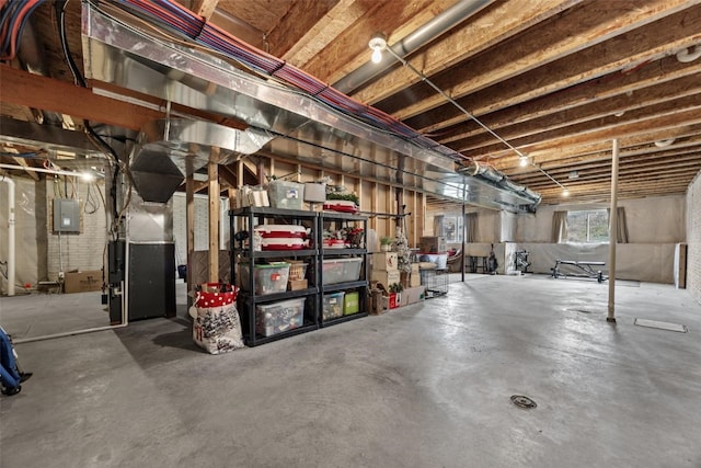 basement with electric panel and heating unit