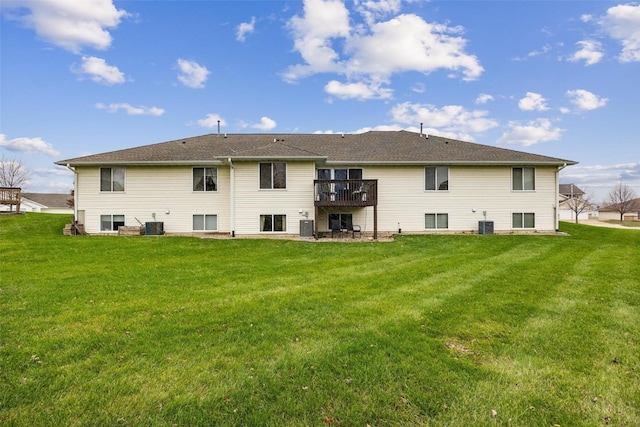 rear view of property featuring central AC and a yard