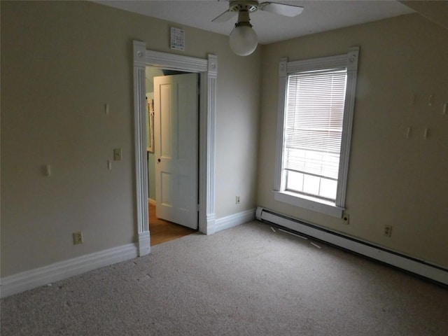 empty room with ceiling fan, plenty of natural light, light colored carpet, and a baseboard radiator