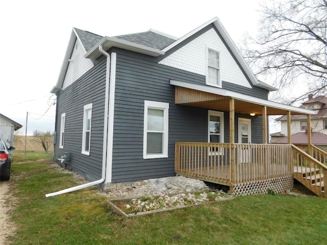 back of house featuring a deck and a lawn