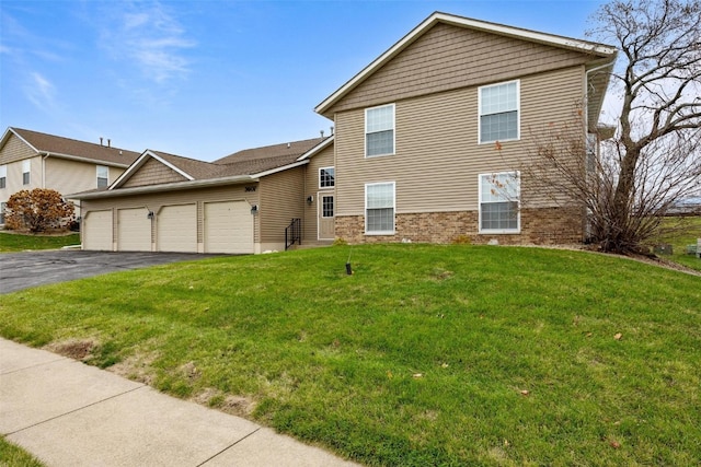 view of property with a garage and a front lawn