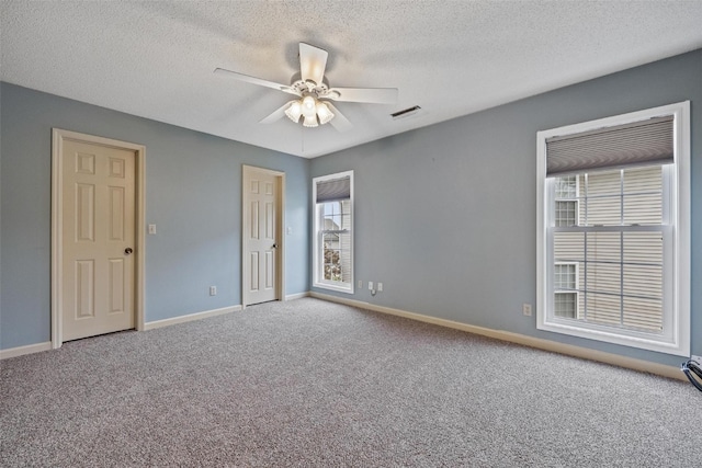 carpeted spare room with a textured ceiling and ceiling fan