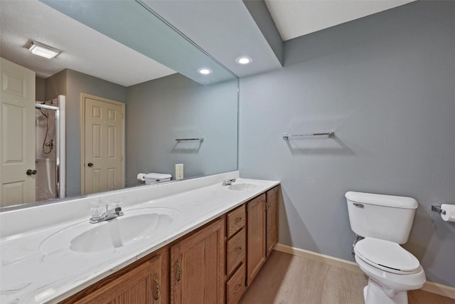 bathroom featuring vanity, wood-type flooring, an enclosed shower, and toilet