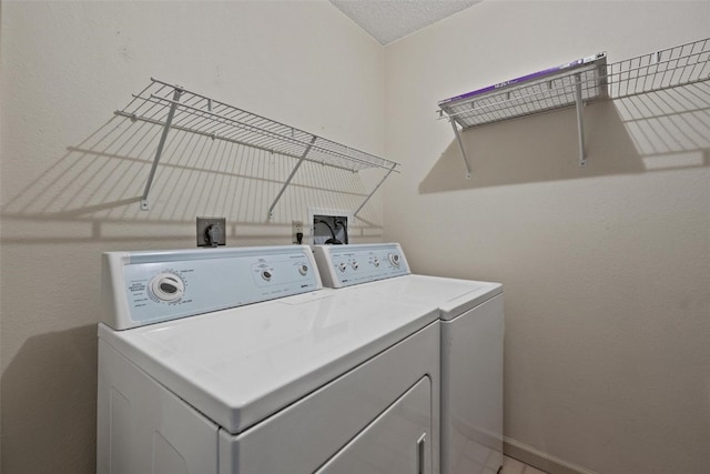 laundry room featuring separate washer and dryer and a textured ceiling