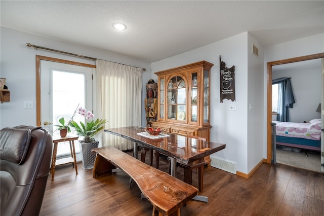 dining space with a healthy amount of sunlight and dark wood-type flooring