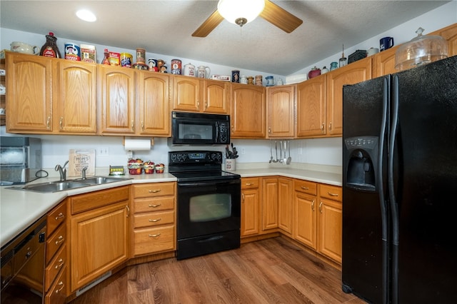 kitchen with ceiling fan, sink, wood-type flooring, a textured ceiling, and black appliances