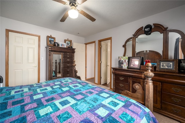 carpeted bedroom featuring ceiling fan and a textured ceiling