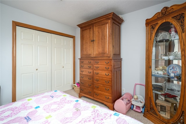 carpeted bedroom with a closet and a textured ceiling