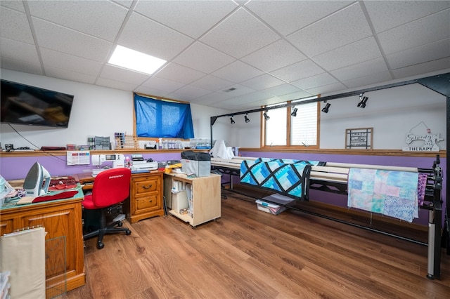 office space with a paneled ceiling and wood-type flooring