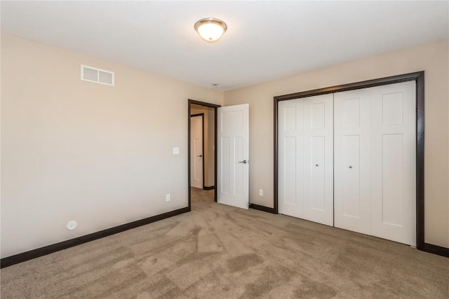 unfurnished bedroom featuring a closet and light carpet