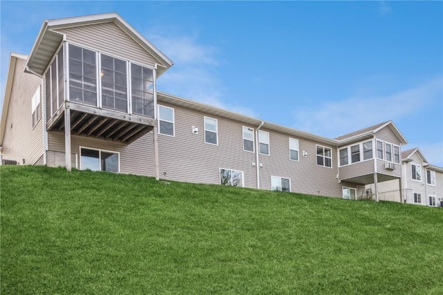 back of property featuring a sunroom and a yard