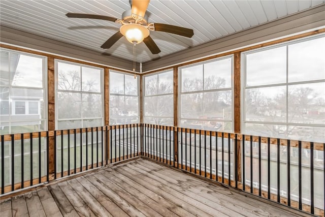 unfurnished sunroom featuring ceiling fan and plenty of natural light