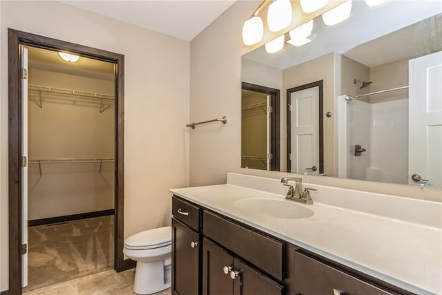 bathroom with vanity, walk in shower, and toilet