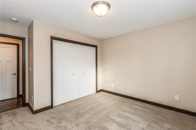 unfurnished bedroom with light carpet and a closet