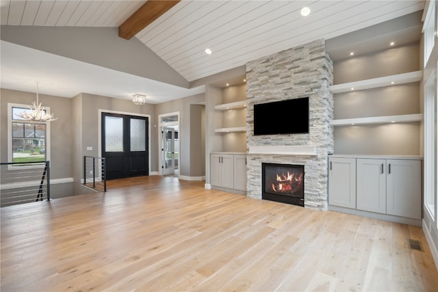 unfurnished living room featuring high vaulted ceiling, light wood-type flooring, a fireplace, beamed ceiling, and a notable chandelier