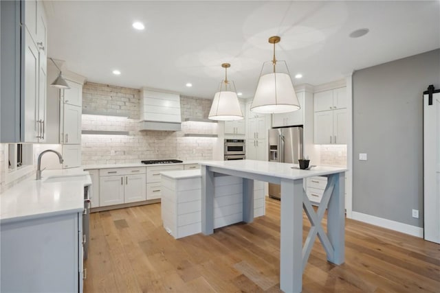 3037 Dell Ridge Ct, Hiawatha, IA 52233 - kitchen featuring appliances with stainless steel finishes, a sink, tasteful backsplash, a center island, and light countertops