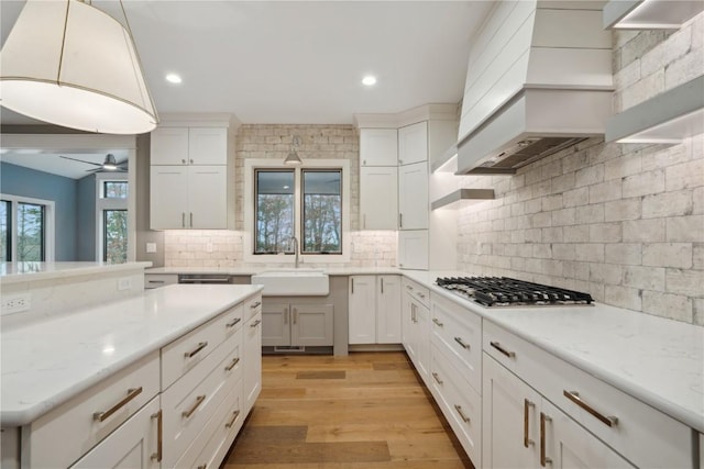 3037 Dell Ridge Ct, Hiawatha, IA 52233 - kitchen with a sink, stainless steel gas stovetop, premium range hood, backsplash, and ceiling fan