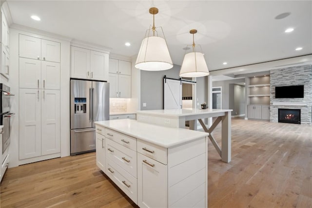 3037 Dell Ridge Ct, Hiawatha, IA 52233 - kitchen featuring high quality fridge, a barn door, light wood-type flooring, recessed lighting, and open floor plan