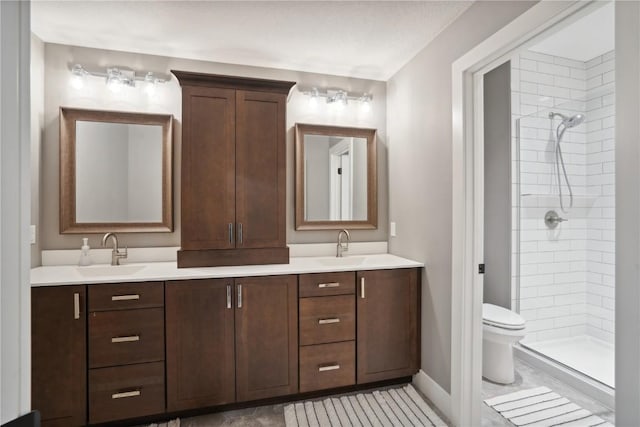 3037 Dell Ridge Ct, Hiawatha, IA 52233 - full bathroom featuring double vanity, a tile shower, toilet, baseboards, and tile patterned floors