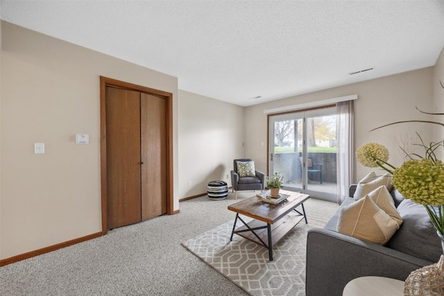 carpeted living room featuring a textured ceiling