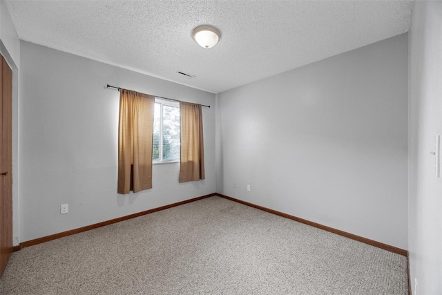 carpeted spare room featuring a textured ceiling