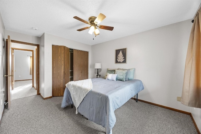 bedroom featuring ceiling fan, light colored carpet, and a textured ceiling