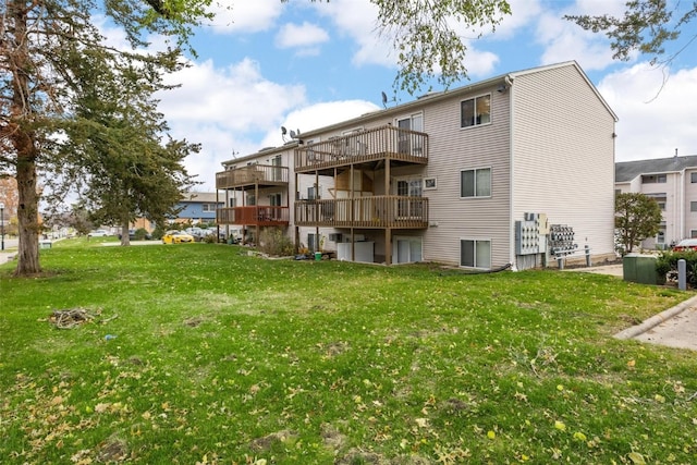 back of house with a yard and a balcony