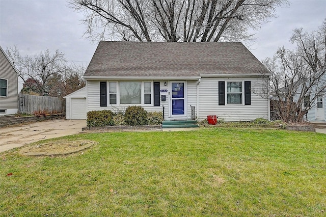 view of front of home with a front yard, a garage, and an outdoor structure