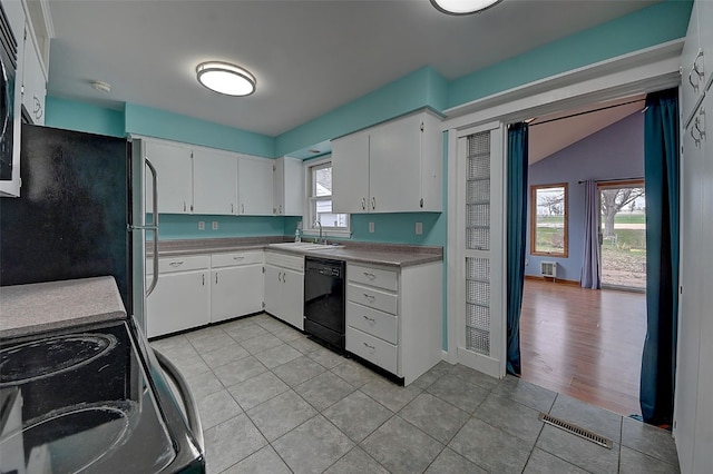 kitchen with white cabinetry, a wealth of natural light, and black appliances