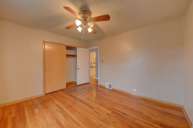 unfurnished bedroom featuring ceiling fan, light wood-type flooring, and a closet