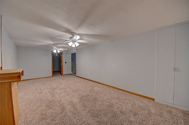 unfurnished bedroom with ceiling fan, carpet floors, and a textured ceiling