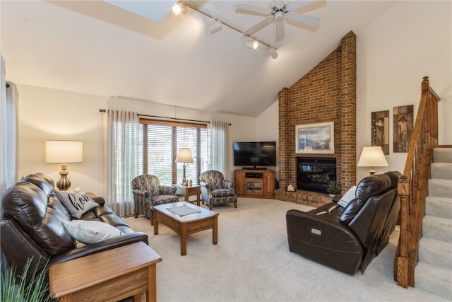 carpeted living room featuring ceiling fan, a fireplace, high vaulted ceiling, and track lighting