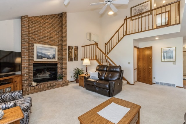 carpeted living room featuring ceiling fan, high vaulted ceiling, and a brick fireplace