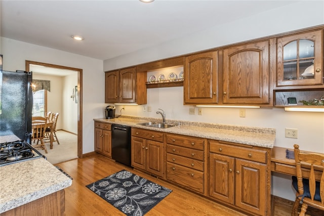 kitchen featuring light stone countertops, sink, black appliances, and light hardwood / wood-style floors