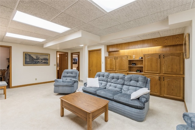 living room featuring light carpet and a drop ceiling