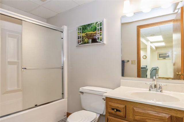 full bathroom with shower / bath combination with glass door, vanity, toilet, and a drop ceiling