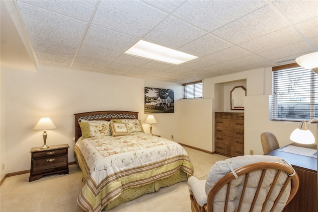 bedroom with light carpet and a drop ceiling