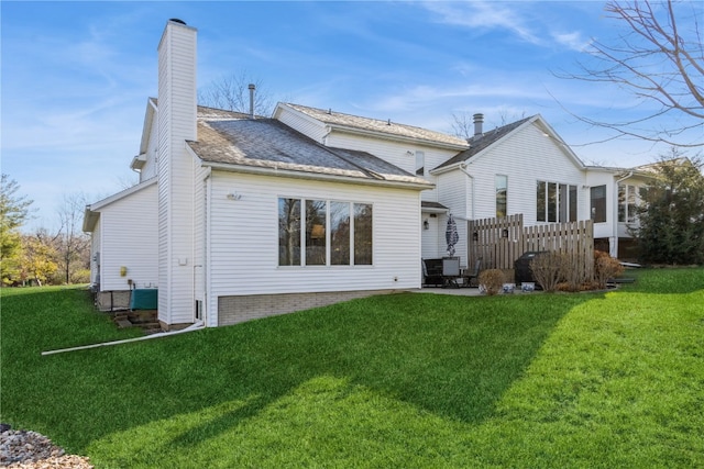 rear view of house featuring a lawn