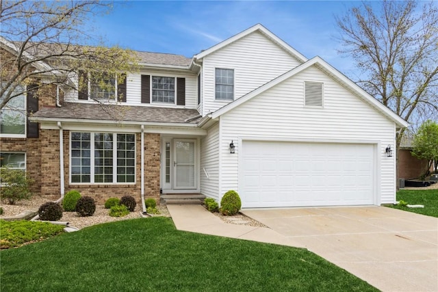 traditional-style home with a garage, brick siding, a front yard, and concrete driveway