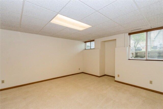 empty room featuring light carpet and baseboards