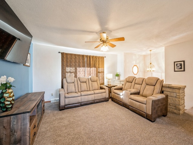 carpeted living room featuring ceiling fan and a textured ceiling