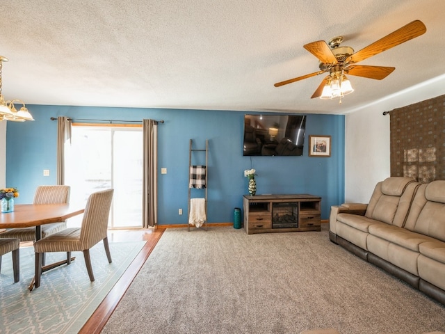 living room with ceiling fan, a textured ceiling, and hardwood / wood-style flooring