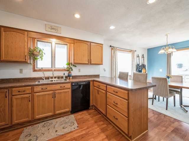 kitchen featuring dishwasher, dark hardwood / wood-style flooring, kitchen peninsula, and a wealth of natural light