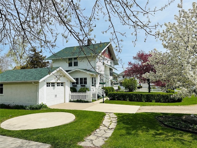 view of front facade with a garage, a front lawn, and an outdoor structure