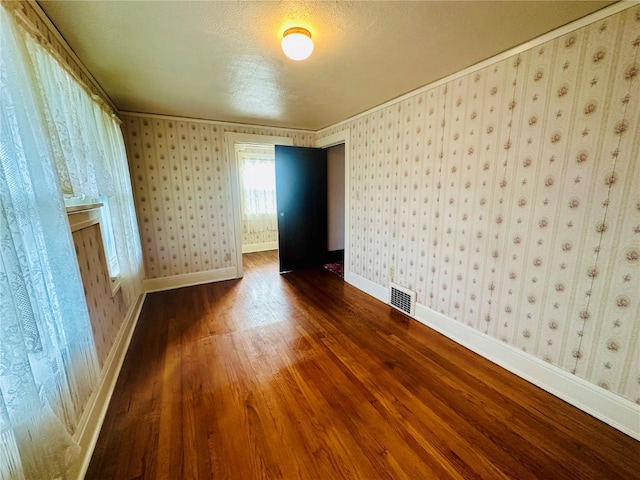 spare room featuring hardwood / wood-style floors and a textured ceiling