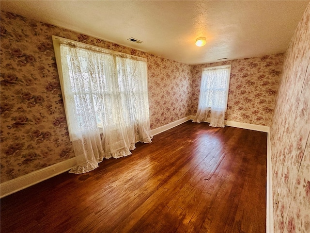 unfurnished room featuring dark hardwood / wood-style floors and a textured ceiling