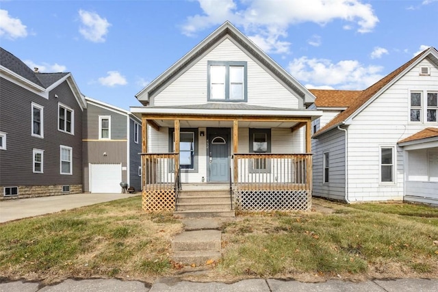 bungalow-style home featuring a front lawn, covered porch, and a garage