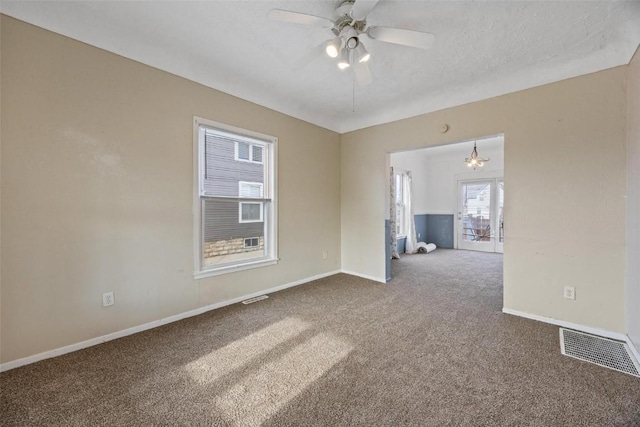 unfurnished room featuring a textured ceiling, carpet floors, and ceiling fan with notable chandelier